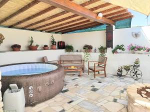 a patio with a hot tub and a table and chairs at HOLIDAY HOME ZLOPOJE in Vis