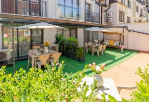 Cet appartement dispose d'une terrasse avec des tables et des parasols. dans l'établissement Sevastopol apartments Varna, à Varna