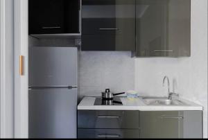 a kitchen with a sink and a refrigerator at VIA VENETO SUITE 529 in Rome