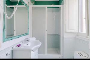 a white bathroom with a sink and a shower at VIA VENETO SUITE 529 in Rome