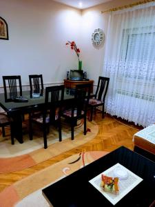 a dining room with a black table and chairs at Stan na dan J & M in Vršac +8 photos