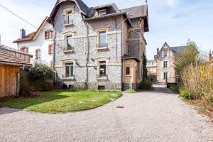 ein altes Haus mit einer Einfahrt davor in der Unterkunft Les Libellules - Maison de caractère 5ch in Gérardmer