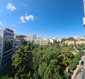 vistas a una ciudad con árboles y edificios en Downtown, penthouse apartment with great view, Pagkrati en Atenas