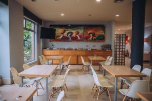 a restaurant with tables and chairs and a large screen at Hotel Arha Mar Comillas in Comillas