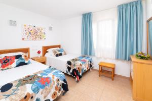 een hotelkamer met 2 bedden en blauwe gordijnen bij MUR Bungalows Parque Romantico in Playa del Inglés +26 foto's