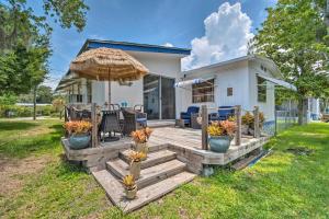 a house with a wooden deck with an umbrella at Homosassa Retreat with Sunroom and Canal Views! in Homosassa