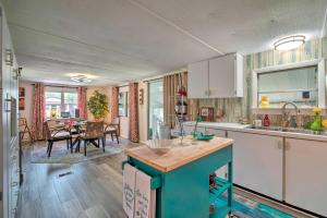 uma cozinha com armários brancos e uma sala de jantar em Homosassa Retreat with Sunroom and Canal Views! em Homosassa