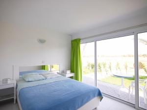 Schlafzimmer mit einem Bett und einer Glasschiebetür in der Unterkunft So Apartments in Ayia Napa