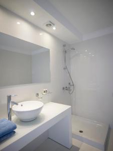 ein weißes Badezimmer mit einem Waschbecken und einem Spiegel in der Unterkunft So Apartments in Ayia Napa
