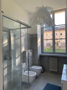 La salle de bains est pourvue de toilettes et d'une douche en verre. dans l'établissement MARTI' S HOUSE, à Olginate
