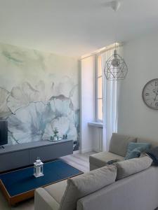 uma sala de estar com um sofá e um mural de flores em MARTI' S HOUSE em Olginate