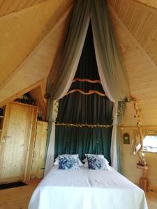 een slaapkamer met een hemelbed bij La Chaumière des Elfes in Servas