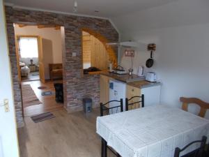a kitchen and dining room with a table and a kitchen and a room with at Boltíves Vendégház in Sajógalgóc