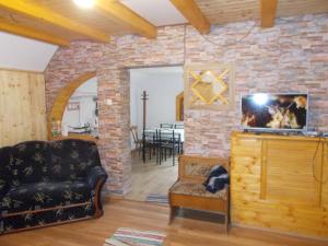 a living room with a couch and a stone wall at Boltíves Vendégház in Sajógalgóc