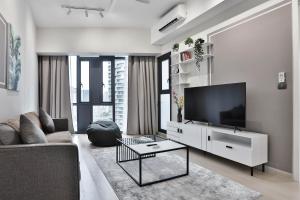 uma sala de estar com uma televisão e um sofá em H&N Luxury Suites KLCC em Kuala Lumpur