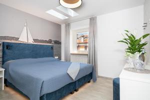 a bedroom with a blue bed and a window at BAUR SUITE - Regarda Travel in Bardolino
