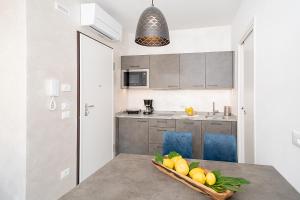 a kitchen with a table with a bowl of fruit on it at BAUR SUITE - Regarda Travel in Bardolino +31 photos