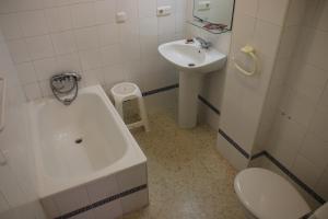 a bathroom with a sink and a tub and a toilet at Pensión Campomar in Cartaya