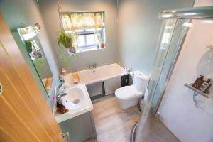 bagno con lavandino, vasca e servizi igienici di Tern Cottage a Groomsport