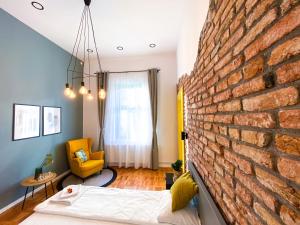 Habitación con pared de ladrillo, cama y silla en Cluj Aparthotel, en Cluj-Napoca
