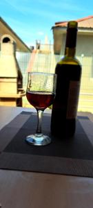 una copa de vino junto a una botella de vino en Maxy, en Schitul