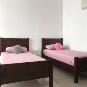twee bedden naast elkaar in een kamer bij Homestay SKS Apartment Larkin Johor Bahru in Johor Bahru