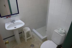 a bathroom with a sink and a toilet and a mirror at Pensión Campomar in Cartaya +4 photos