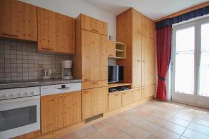 eine Küche mit Holzschränken und einem großen Fenster in der Unterkunft Appartement Dachsteingasse by Schladming-Appartements in Schladming