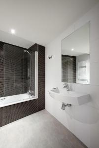 a bathroom with two sinks and a shower and a tub at Apartaments Terraza Figueres in Figueres