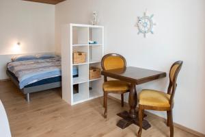 Schlafzimmer mit einem Schreibtisch und einem Bett sowie einem Tisch und Stühlen in der Unterkunft Neptun 2 (im Zentrum von Bad Ragaz) in Bad Ragaz
