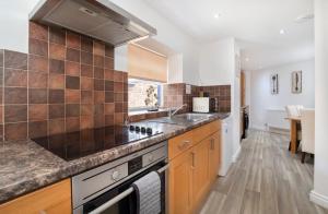 a kitchen with a sink and a stove at 1 Ascot Mews - City of York Holiday Home in York