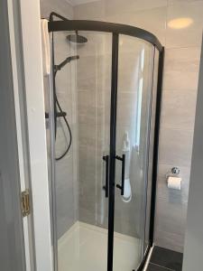 a shower with a glass door in a bathroom at Eyre Square Lane Budget Rooms in Galway