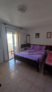 a bedroom with a bed with purple sheets and a window at Ema Apartments in Ulcinj