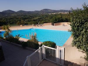 una gran piscina azul con una valla blanca en Le '47' Village de Campagne, 83310 Cogolin, en Cogolin