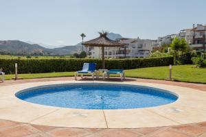 - une piscine avec 2 chaises bleues et une table dans l'établissement Gran Terrassa Del Eucalyptus, à Malaga