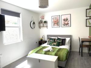 a bedroom with a green and white bed and a table at The Green Room - Worthing in Worthing