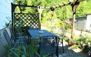 a table and chairs in a garden with a pergola at Ferienwohnung Evi in Walkenried