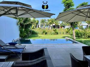 ośrodek z basenem i parasolem w obiekcie Villa Panda - Sanctuary Ho Tram Resort w mieście Hồ Tràm