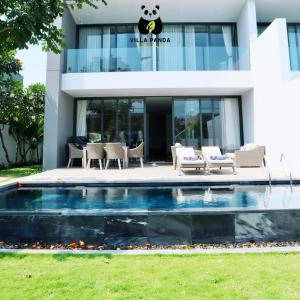 a house with a swimming pool in front of a building at Villa Panda - Sanctuary Ho Tram Resort in Ho Tram