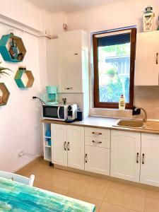 a kitchen with a sink and a microwave on a counter at Arcadia Apartament Mamaia Nord in Mamaia Nord
