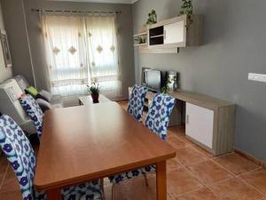 - une salle à manger avec une table et des chaises en bois dans l'établissement Apartamento en la playa, à Les Cases d'Alcanar