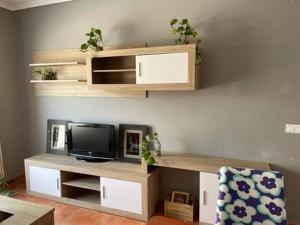 a living room with a tv on a shelf at Apartamento en la playa in Les Cases d'Alcanar