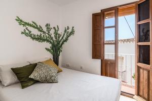 una camera con un letto bianco e una finestra di Town house with roof terrace and plunge pool ad Alcaucín