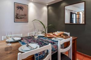 a dining room with a wooden table with plates and glasses at Town house with roof terrace and plunge pool in Alcaucín