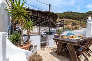 a patio with a wooden table and some plants at Town house with roof terrace and plunge pool in Alcaucín