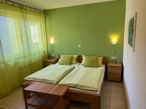 ein Schlafzimmer mit einem großen Bett mit grünen Wänden in der Unterkunft Reis - feine Weine "Am Weingut" in Briedel