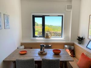 une salle à manger avec une table en bois et une fenêtre dans l'établissement Porth Oer, à Nefyn