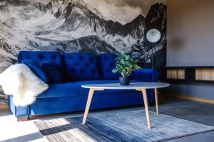 Un sofá azul en una sala de estar con una mesa. en 285 Apartments, en Czarny Dunajec