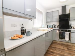 una cucina bianca con un piatto di pane sul bancone di Kilmuir Cottage a Tomintoul Altre 18 foto