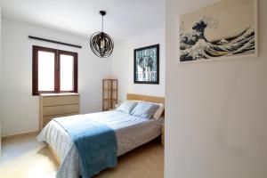 a bedroom with a bed and a painting on the wall at BEACH FRONT GRANILLO - ocean view, garden, bright and comfortable, Wi-Fi in Costa Calma